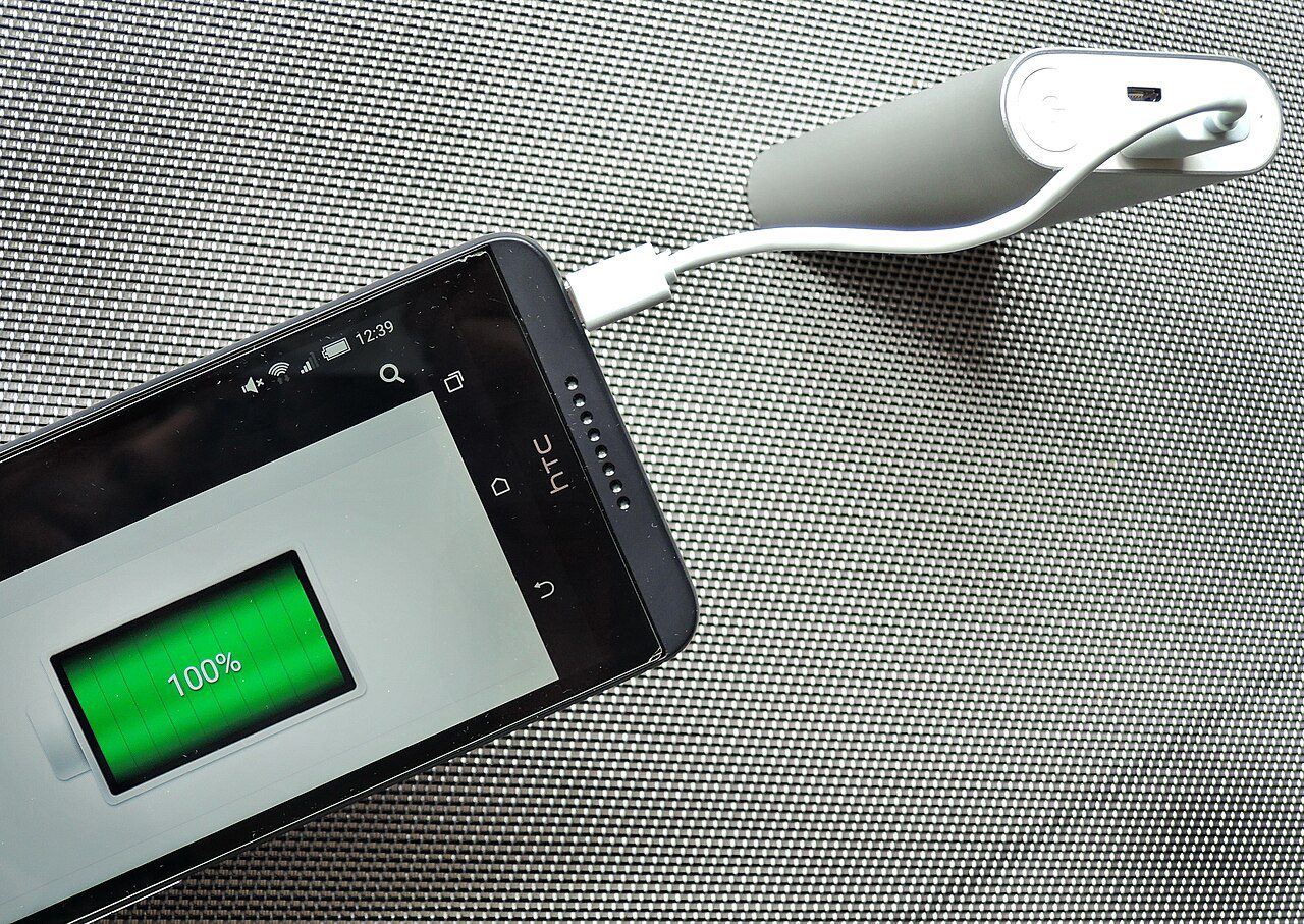 smartphone charging on a desk for tips to make a phone last all day
