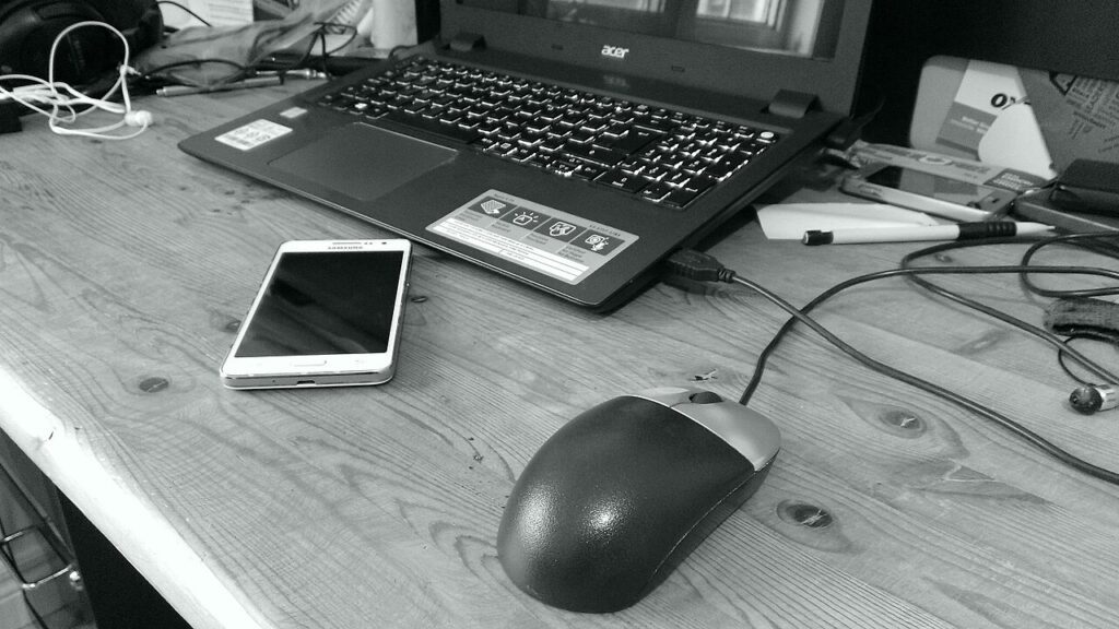 laptop and phone on a desk for organizing downloaded files