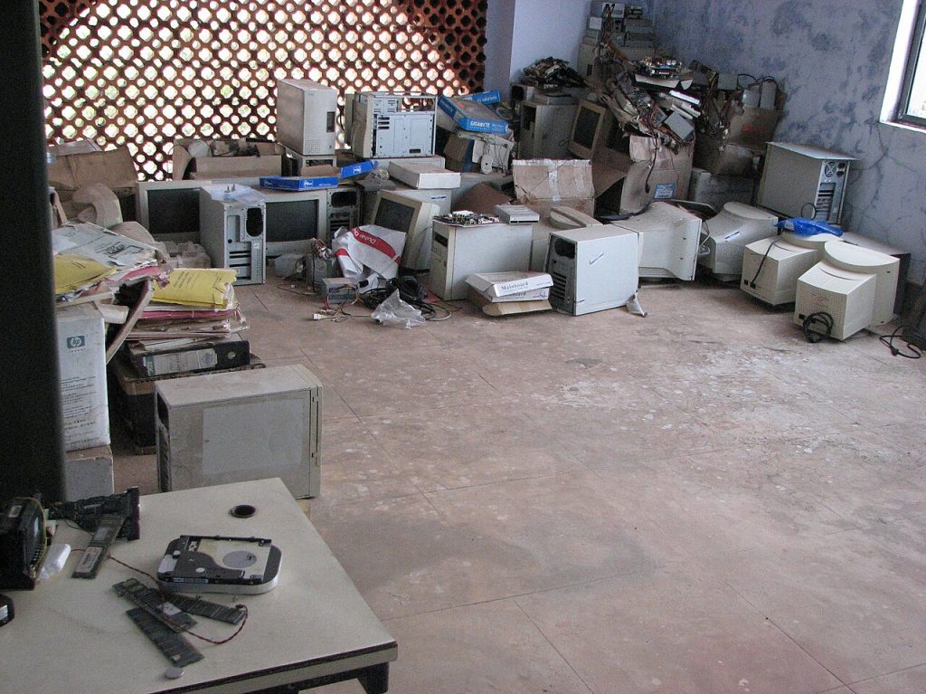 dispose of old electronics at an e-waste collection point with used devices and cables